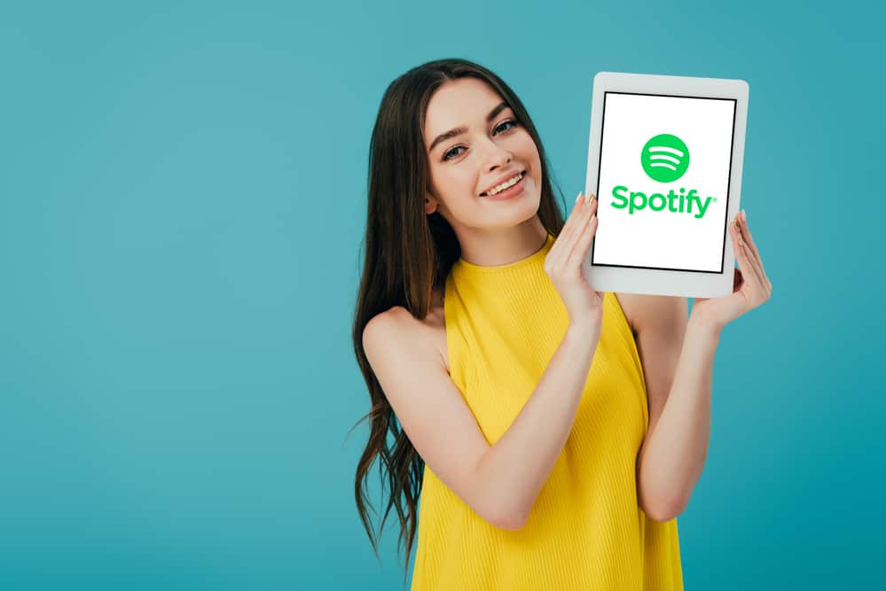 Жінка тримає планшет із додатком spotify