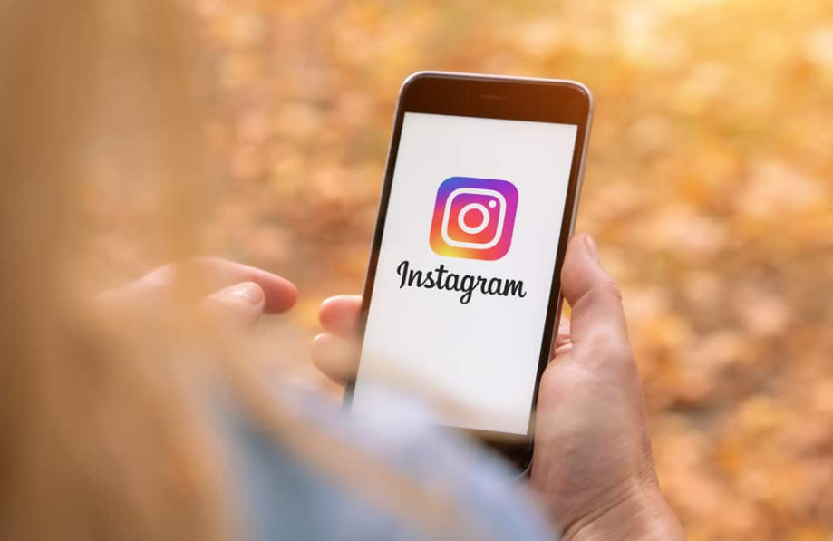 жінка тримає телефон із додатком instagram