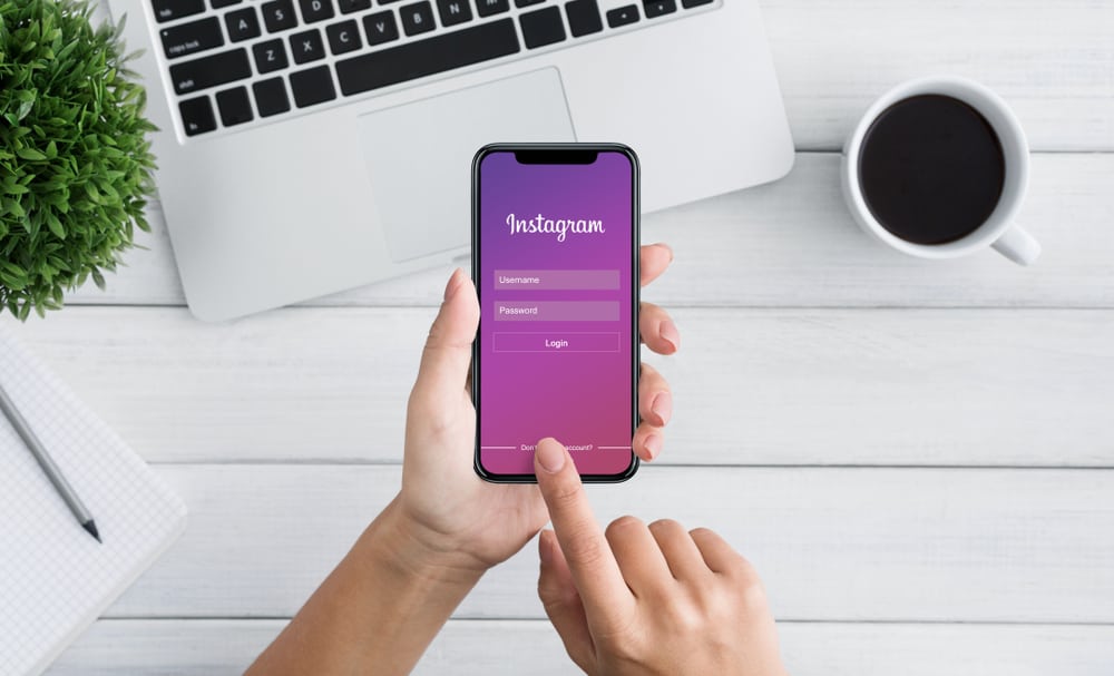 Жінка увійшла за допомогою програми Instagram на екрані Iphone X. Instagram – це програма для обміну фотографіями та відео
