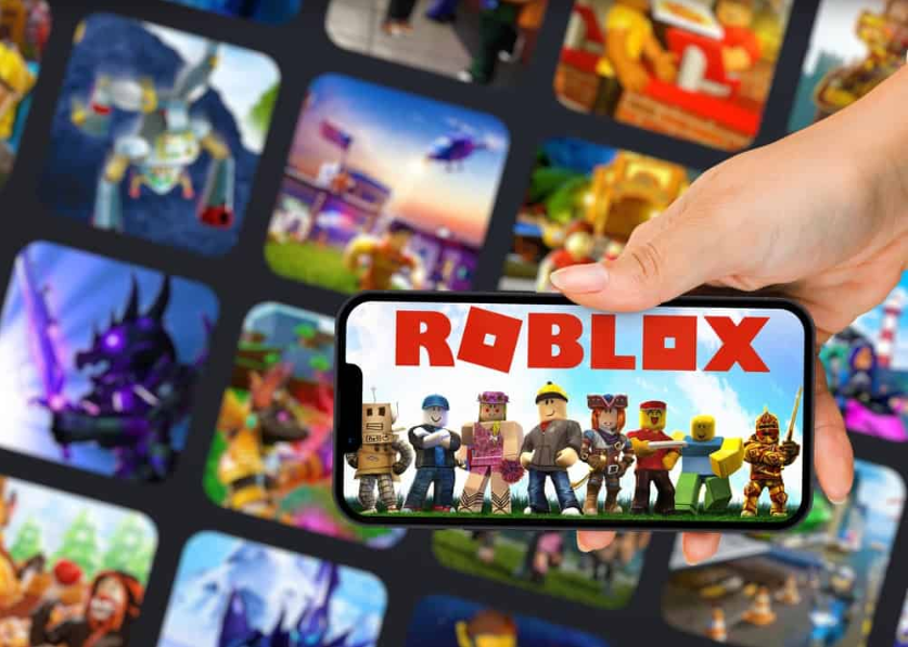 Жіноча рука тримає смартфон із мобільною ігровою програмою Roblox на смартфоні