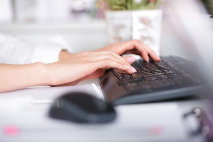 жіночі руки друкують на клавіатурі ноутбука.