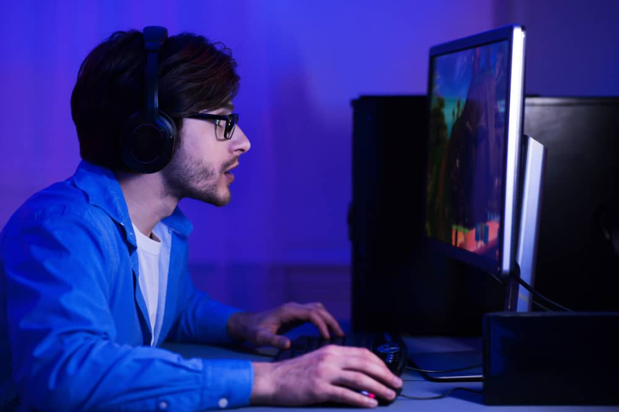 Зосереджений хлопець грає в шутер у навушниках